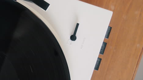 male putting on a vinyl record on an automatic turntable