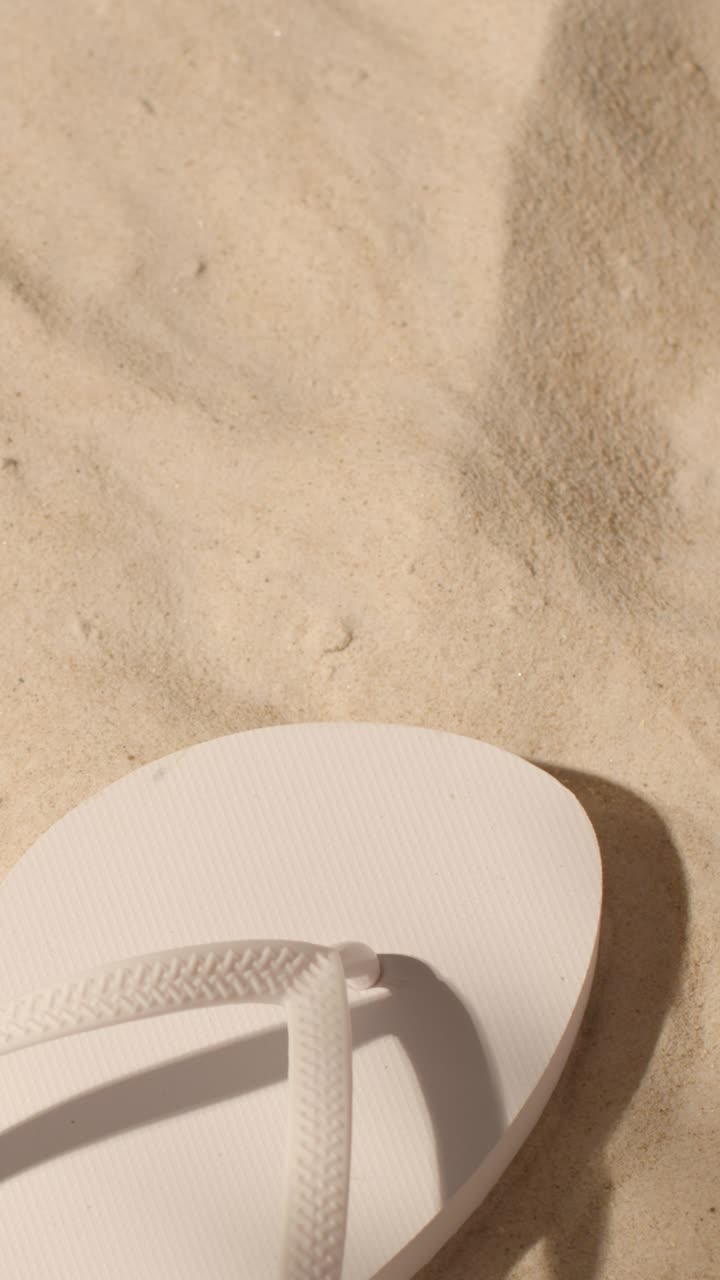 모래 배경에 플립 플롭과 차가운 음료의 수직 여름 휴가 개념