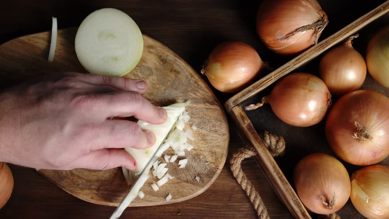 Men hands cut onion into small pieces on a cutting Board.