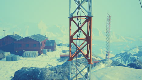 una alta torre de metal se encuentra en una montaña nevada