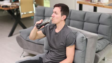 man drinking soda on a couch