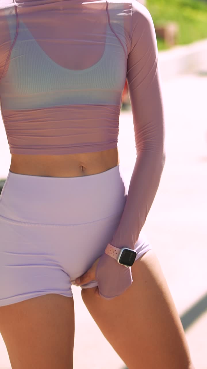 スポーツウェアを着て屋外でショートパンツを調整する若い女性