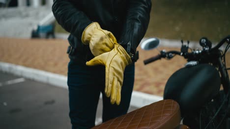 man putting on motorcycle gloves