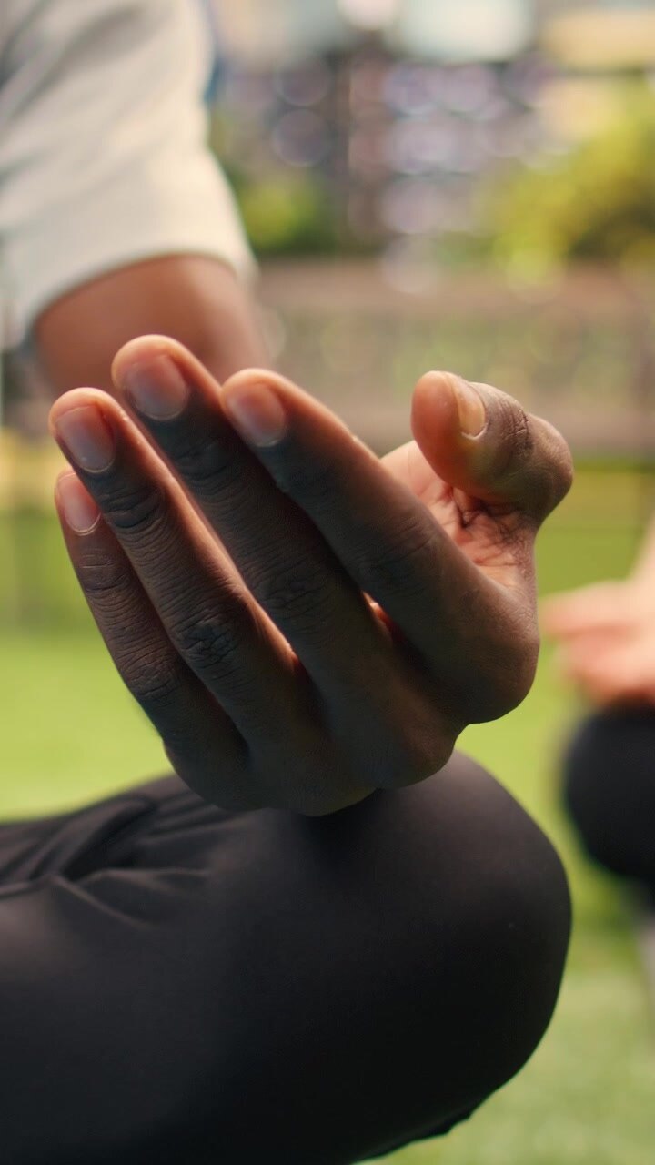 Video verticale in primo piano di un uomo che medita con i palmi aperti durante una sessione di yoga all'aperto