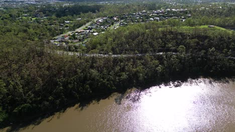 oxenford, gold coast, 4 january 2024 - aerial views of the road adjacent to the coomera river in oxenford with stripped trees from the january storms