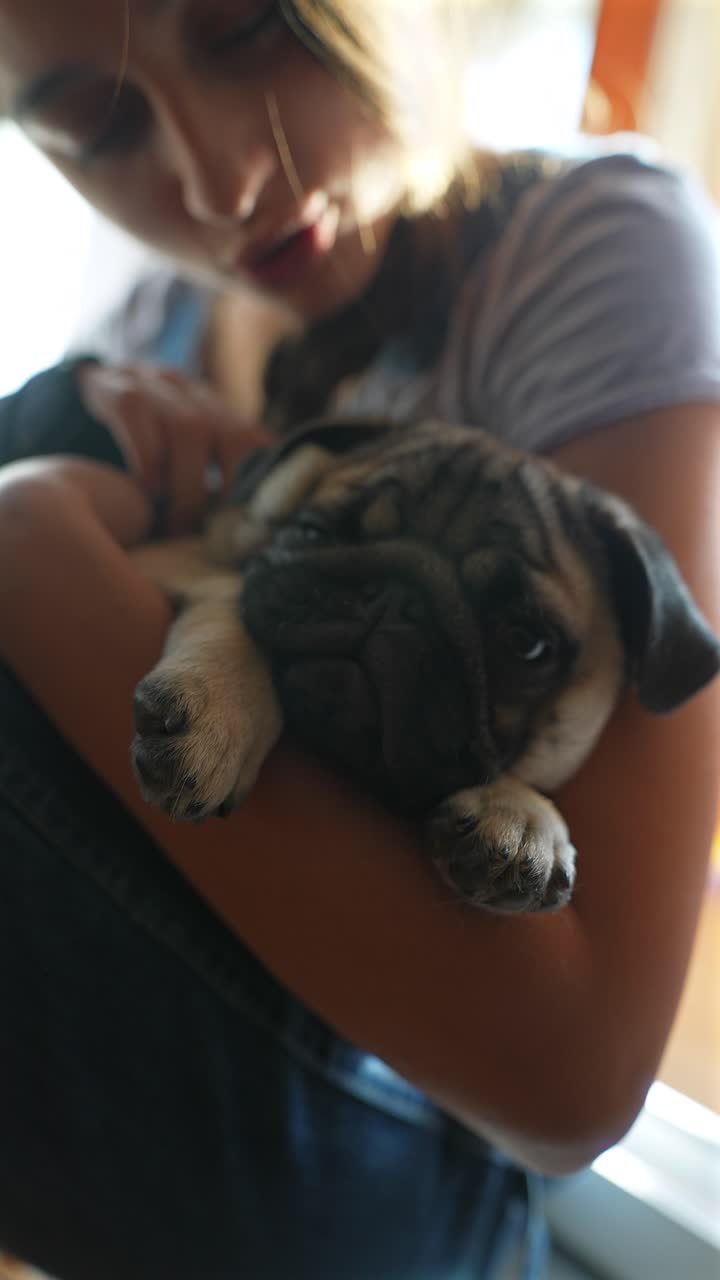 una chica con un cachorro de pug