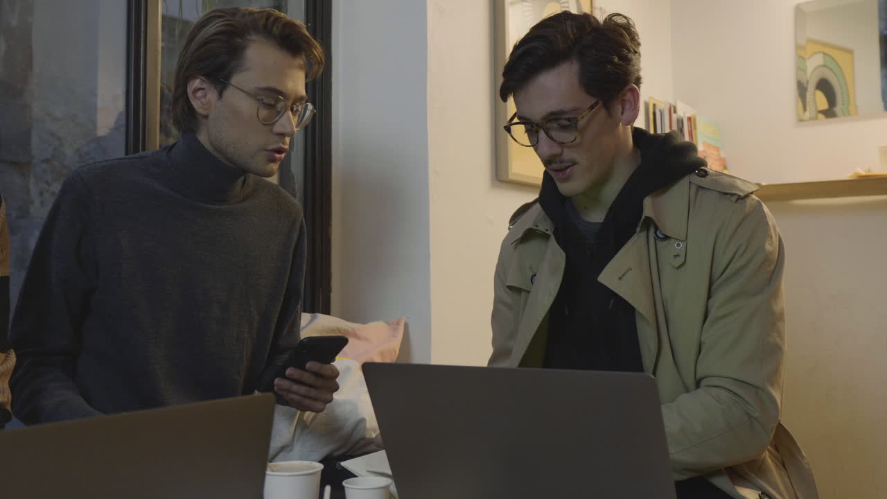 카페 에서 회의 를 하는 사업가 들. 스마트 폰 에서 인터넷 을 검색 하는 사업가 들