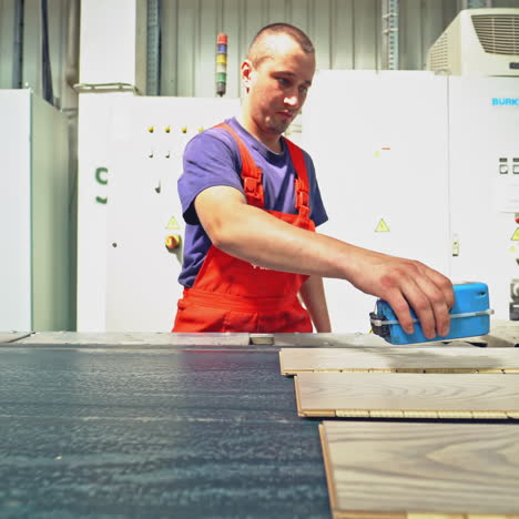 a young worker in wood factory. floorboard production. modern technologies.