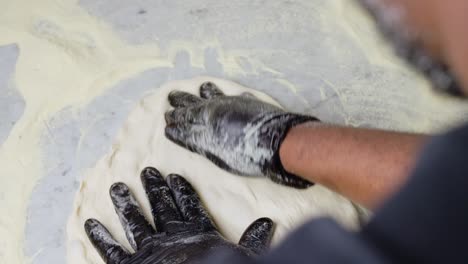 chef making a pizza dough spreading it