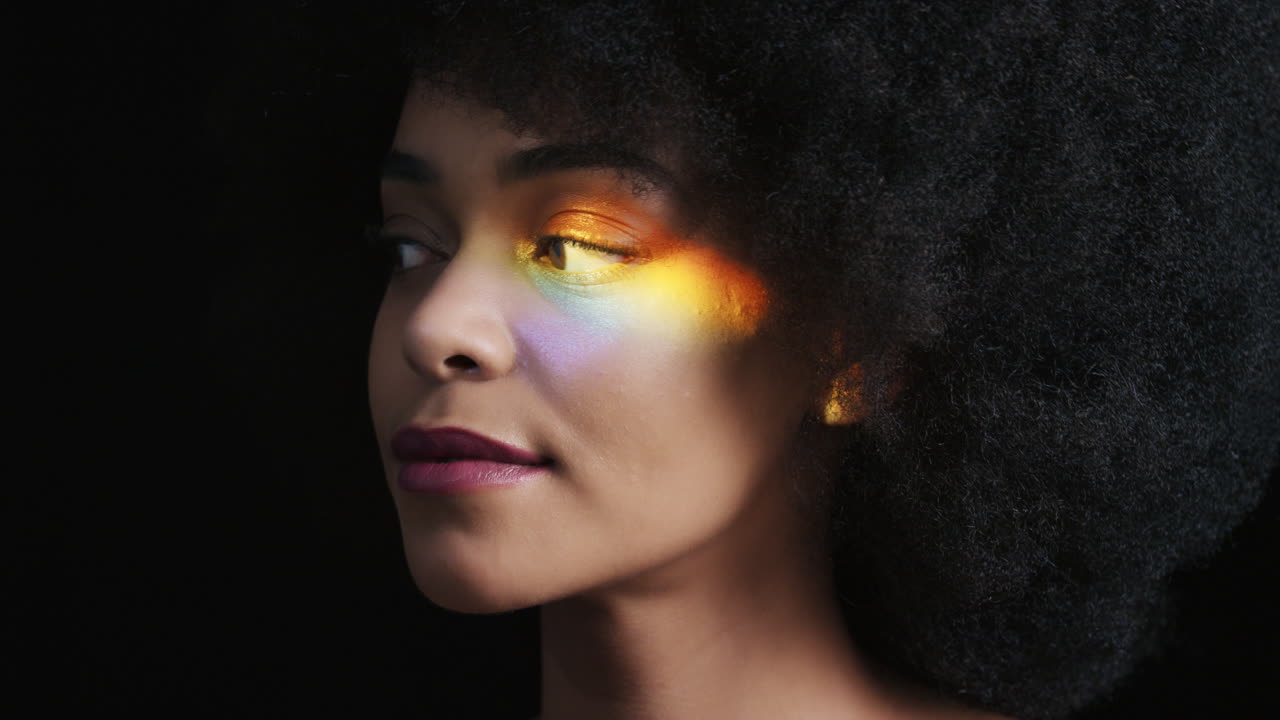 retrato multicolor de cerca hermosa mujer afroamericana con piel suave y saludable con aspecto confiado belleza natural luz colorida sobre fondo negro concepto de cuidado de la piel