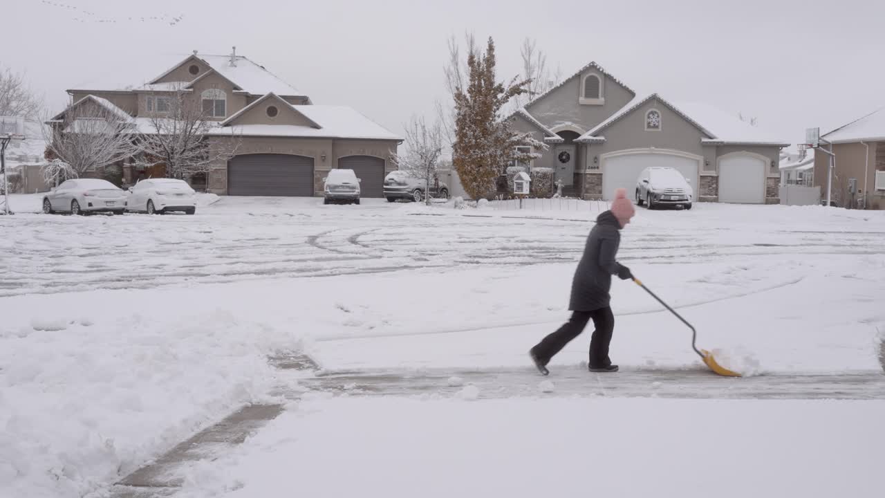 그녀의 진입로에서 눈을 삽질하는 고위 여자