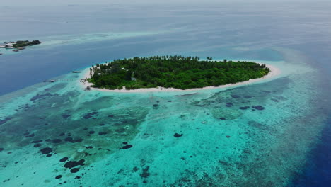drone orbit of circular atoll surrounded by shallow reefs in blue sea, establishing overview aerial