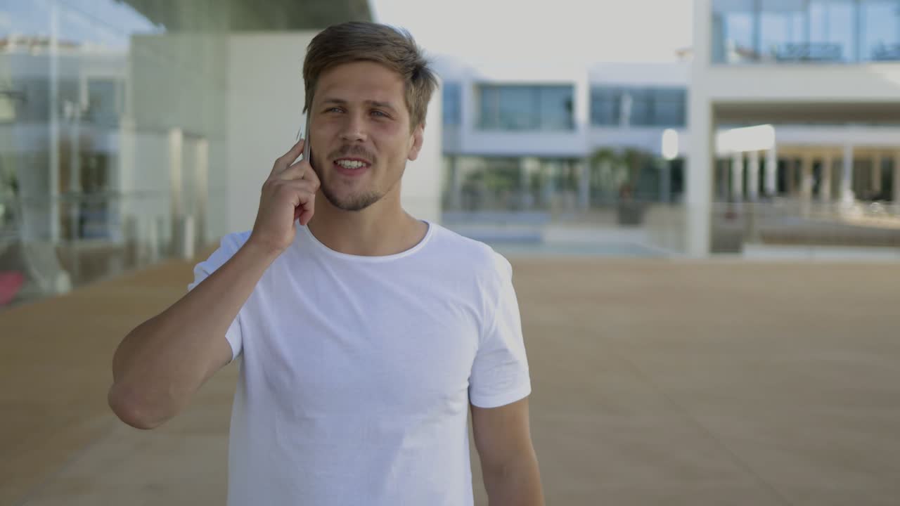 Giovane uomo di successo che parla al telefono durante una passeggiata.