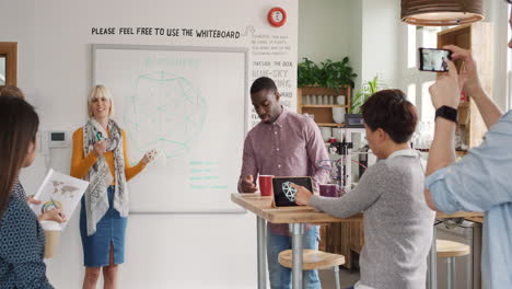 reunión de negocios de grupo diversa líder del equipo femenino presentando la idea del plan de crowdsourcing a los inversores de startups tecnológicas en una oficina hipster de moda que tiene una impresora 3d objeto cúpula geodésica