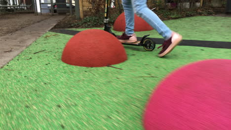 close up of a child riding scooter, tracking shot