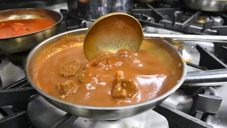 preparation of traditional hyderabadi mutton korma in a restaurant kitchen