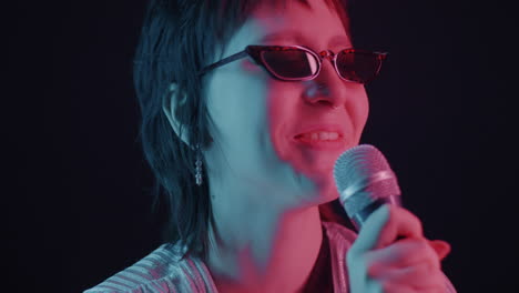 woman singing with microphone in neon lights
