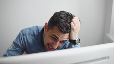 Exhausted-and-frustrated-young-businessman-sitting-at-office-desk,-he-is-touching-his-head.-shot-in-4k