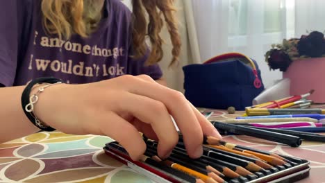 Close-up-shot-of-girl-drawing-a-picture-with-pencils