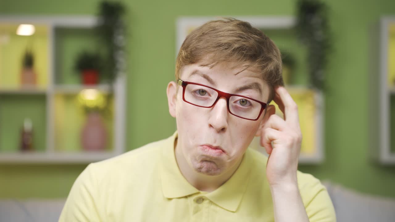 Close-up of cheerful young man looking at camera coming up with ideas.