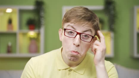 close-up of cheerful young man looking at camera coming up with ideas.