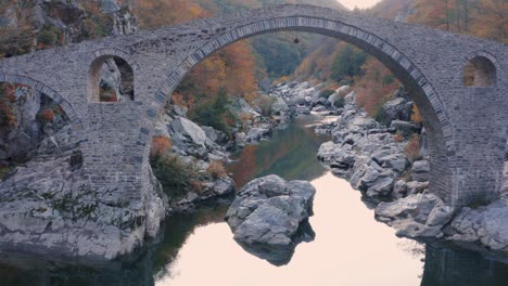 Revelando-El-Puente-Del-Diablo-En-La-Cima-De-Ardino-Bulgaria-En-El-Río-Arda,-Es-Un-Puente-De-Arquitectura-Otomana-En-Las-Montañas-Rodopi