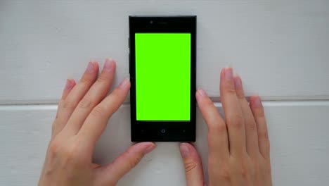 mujer mirando un teléfono inteligente con pantalla verde