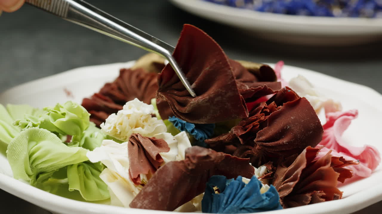Chef Arranging Colorful Chocolate Flowers on a Plate