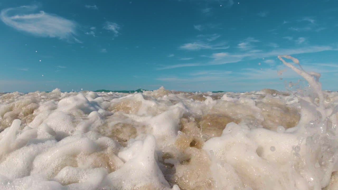 vista del nivel del agua de las olas del caribe rodando en la playa de arena a medida que la cámara se sumerge en las olas