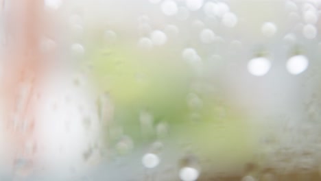 close-up, slow pan across water droplets on glass to focused droplets