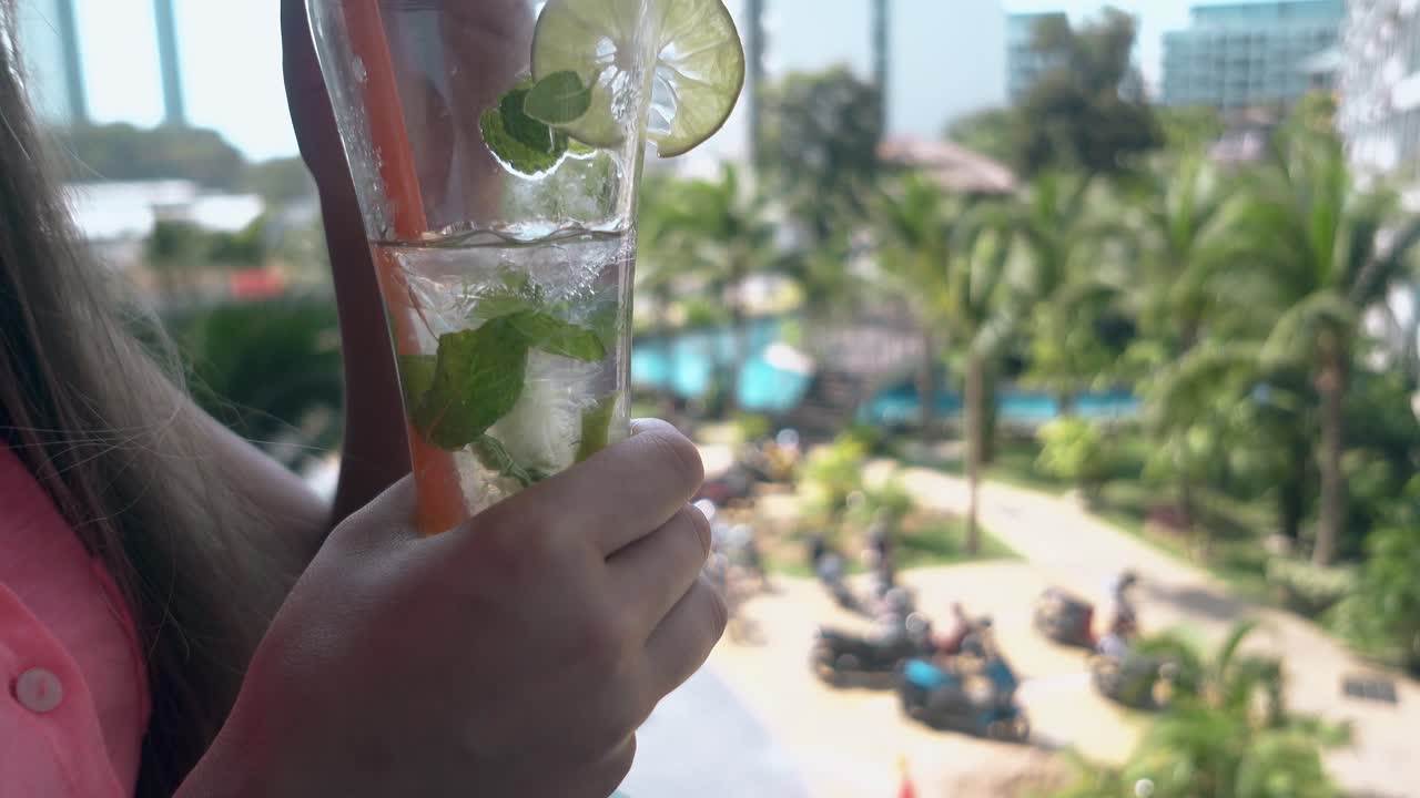 여자는 라임 조각으로 맛있는 상쾌한  ⁇ 테일을 즐긴다.