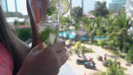 vrouw geniet van een smakelijke verfrissende cocktail met limoensneden