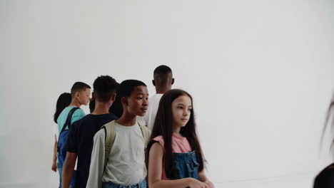 diverse group of students walking in a line indoors