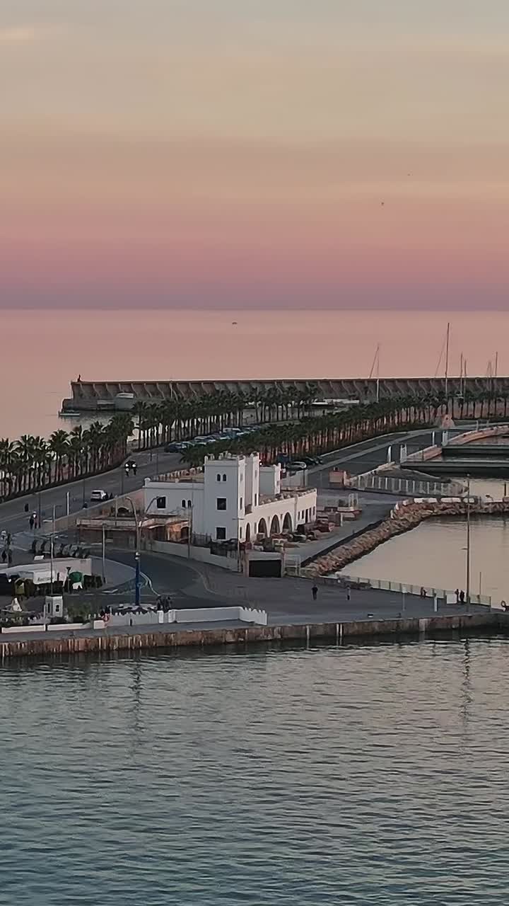 Vista del tramonto sul porto di Malaga, Spagna, con faro e acque calme