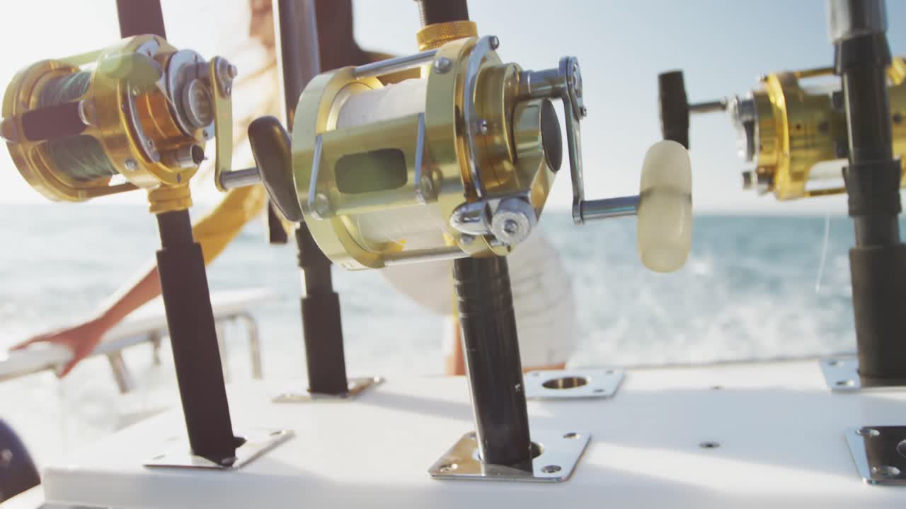 Side view of a teenage Caucasian girl on boat with fishing rods on the foreground