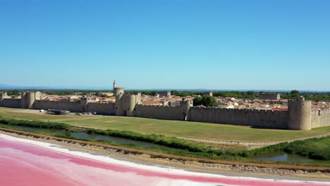 The-historical-town-of-Aigues-Mortes-in-the-Camargue,-France-during-a-sunny-summer-day-which-is-located-next-to-a-pink-salt-lake