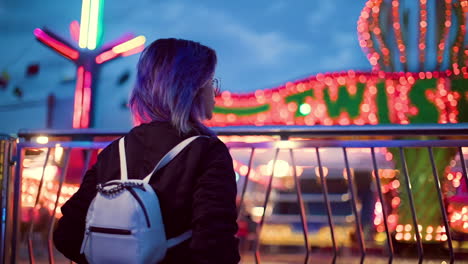 young woman enjoying the vibrant night lights at a fair