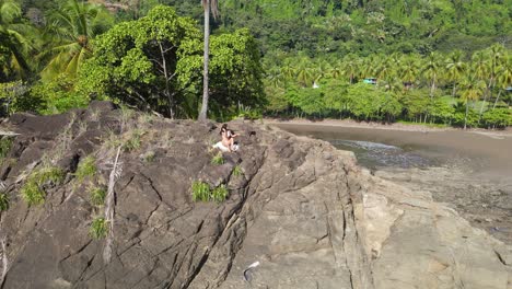 Mujer-Joven-Sentada-En-La-Cima-De-La-Montaña-Y-Descansando-Y-Mirando-A-La-Vista