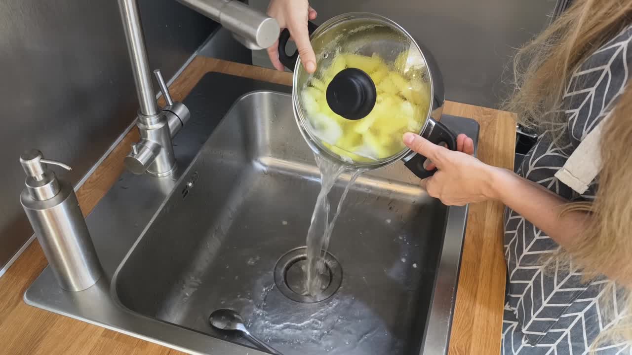 Lavando patatas en el fregadero de la cocina