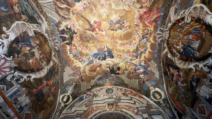 Vista a movimento lento di un soffitto a volta riccamente dipinto, pieno di scene religiose colorate e dettagli ornamentali nella Certosa di Miraflores, Burgos