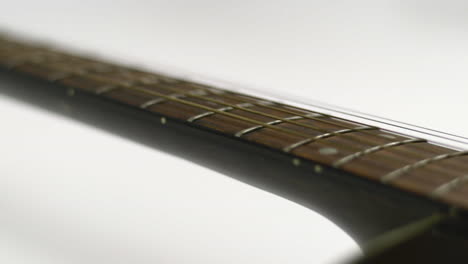 low sideways sliding view of an acoustic guitar