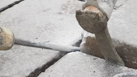 breaking concrete with jackhammer and pickaxe