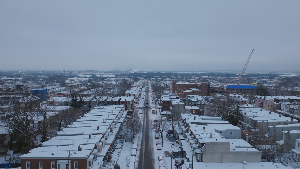 Straight aerial drone footage of a snow covered street in the early morning in West Philadelphia, Pennsylvania.