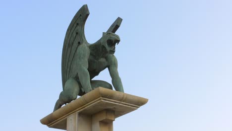 Ferocious-large-bronze-green-Gargoyle-statue-overlooking-the-landscape--Close-up