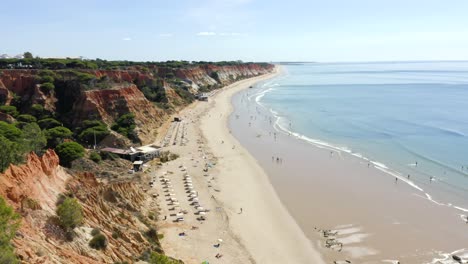 Vista-Aérea-De-La-Playa-De-Falesia-Que-Disfrutan-Los-Turistas-Durante-Las-Vacaciones-De-Verano-En-Albufeira,-Portugal