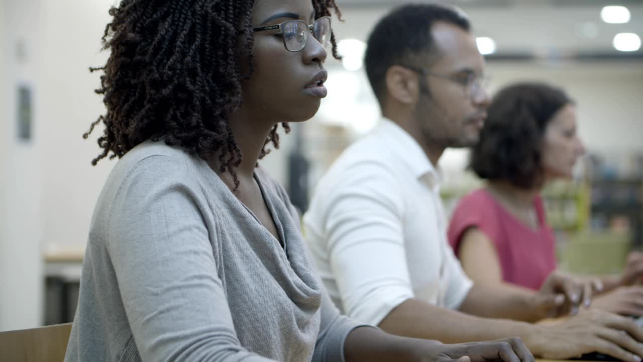 mujer afroamericana enfocada escribiendo en el teclado