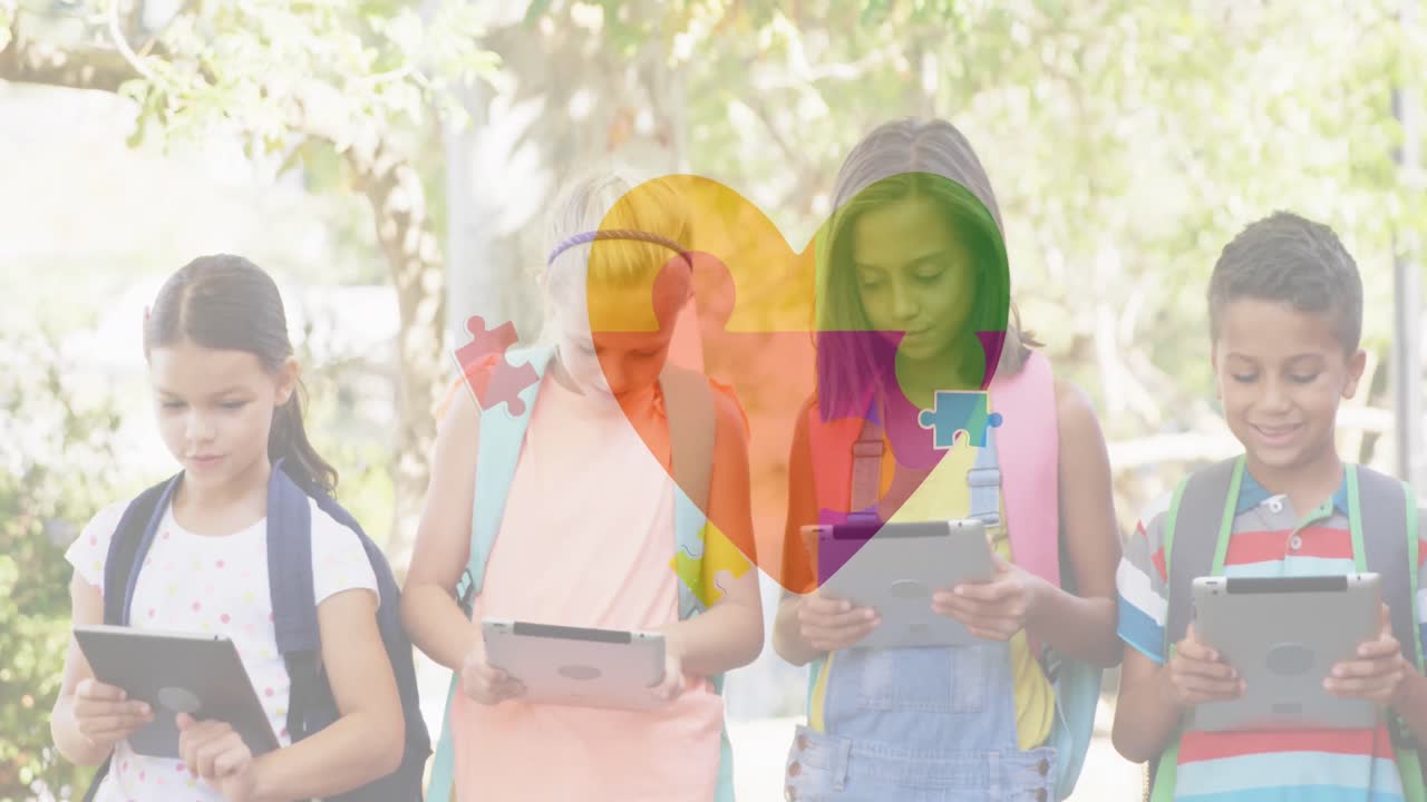 animación de coloridas piezas de rompecabezas corazón sobre niños de escuela usando tabletas