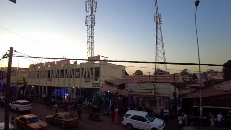 transition pan left high angle view of main serekunda market street traffic during sunset