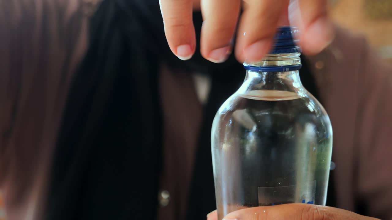 물 병 을 열고 있는 사람