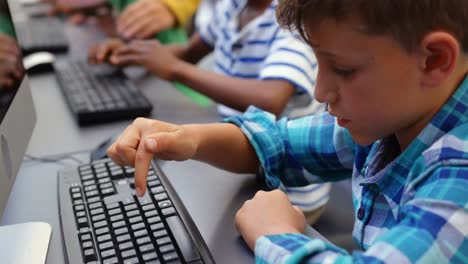 Side-view-of-mixed-race-schoolkids-studying-on-computer-in-the-classroom-4k